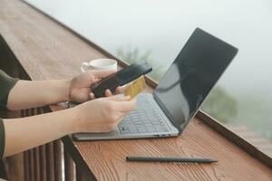 online payment, young woman holding credit card and touching on smartphone screen, copy space photo