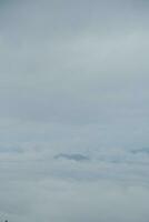 Mountain range with visible silhouettes through the morning blue fog. photo