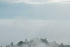 Mountain range with visible silhouettes through the morning blue fog. photo