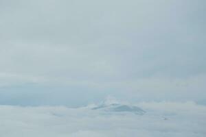 Mountain range with visible silhouettes through the morning blue fog. photo