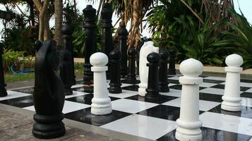 Big chess on giant chessboard in park outside. photo