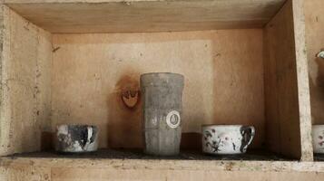 Old wooden cupboard with dirty and old clay pots photo