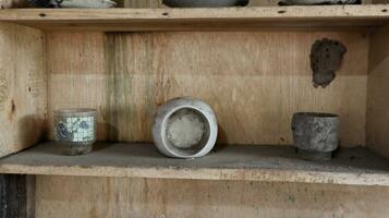 Old wooden cupboard with dirty and old clay pots photo