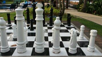 Big chess on giant chessboard in park outside. photo