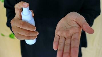 Hand of lady that applying alcohol spray or anti-bacteria spray to prevent the spread of germ photo