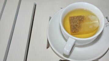 Healthy chamomile tea is poured into a white cup photo