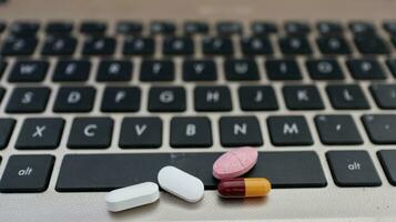 varios tipos de drogas, metido en un ordenador portátil teclado foto