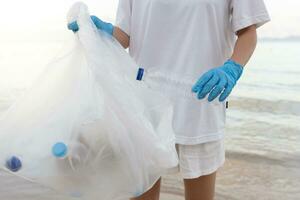 Save water. Volunteer pick up trash garbage at the beach and plastic bottles are difficult decompose prevent harm aquatic life. Earth, Environment, Greening planet, reduce global warming, Save world photo