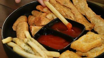 francés papas fritas, pepitas y delicioso frito otak otak servido con picante salsa foto