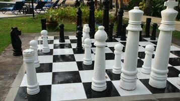 Big chess on giant chessboard in park outside. photo