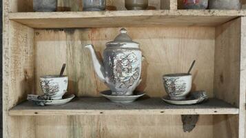 Old wooden cupboard with dirty and old clay pots photo