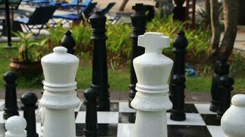 Big chess on giant chessboard in park outside. photo