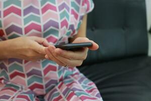 Mobile phone in hand, hand using mobile phone in home photo