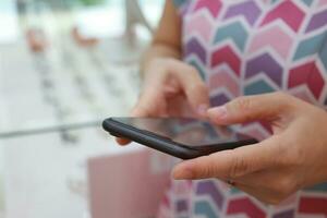 Mobile phone in hand, hand using mobile phone in home photo