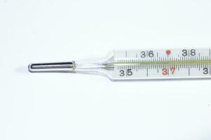 mercury thermometer showing a fever in close-up on a smooth background photo