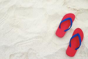 sea on the beach Footprint  people on the sand and slipper of feet in sandals shoes on beach sands background. travel holidays concept. photo