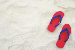 sea on the beach Footprint  people on the sand and slipper of feet in sandals shoes on beach sands background. travel holidays concept. photo