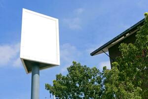 Post sign blank outdoor on the sky and tree. photo