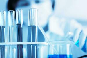 Female medical or scientific researcher using test tube on laboratory. photo