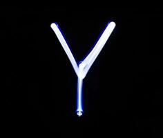 Y Yankee alphabet hand writing blue light  over black background. photo