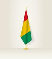 Guinea bandera en un bandera pararse. vector