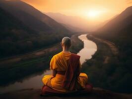 Buddhist monk in meditation on mountaintop at beautiful sunset or sunrise photo