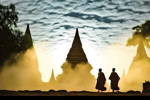 Young Buddhist novice monks walking with background of pagodas during sunrise at Myanmar. photo