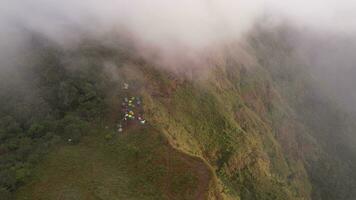 alto angolo Visualizza di campeggio nel il montagne di persone chi venire per camminare nel il foresta, coperto con nebbia, il leggero nel il mattina o sera è Bellissima. video