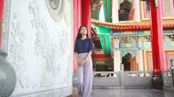 ung asiatisk kvinna reser på ett gammal kinesisk tempel till ser de atmosfär inuti ett gammal kinesisk tempel. video
