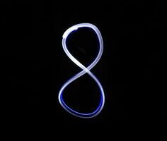 Eight blue light digit hand writing over black background. photo