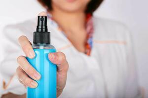 Women holding spray blue bottle. photo