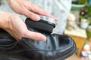 Hands polish leather black shoes. photo