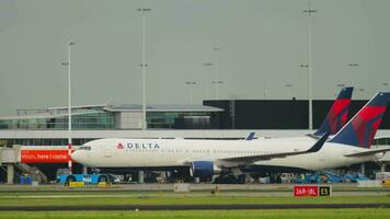 amsterdam, das Niederlande Juli 27, 2017 - - boeing 767 von Delta Fluggesellschaften rollen beim Schiphol Flughafen, Amsterdam. Traktor Abschleppen ein Flugzeug. Tourismus und Reise Konzept video