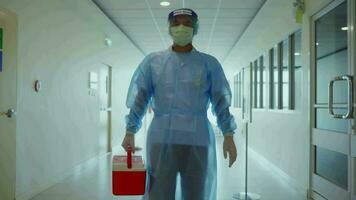 une médecin portant médical protecteur Vêtements est précipitamment en marchant en dehors de le chambre, apportant le spécimen collection boîte à le suivant marcher. à le hôpital video