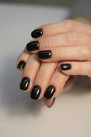 Dark manicure. Dark gel polish on the nails of a girl. Dark manicure with soft square nails. Gel polish coatings photo