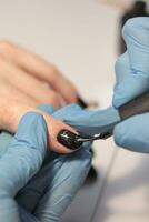 At the nail salon. Manicurist applies dark gel polish. The process of creating a manicure photo