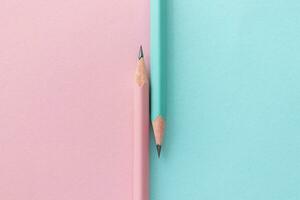 Pastel simple pencils on a pink-blue background. School pencils in pink and blue colors. Two pencils photo