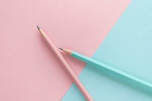 Pastel simple pencils on a pink-blue background. School pencils in pink and blue colors. Two pencils photo