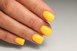 amarillo manicura. cuadrado uñas con gel polaco. soleado y brillante manicura foto