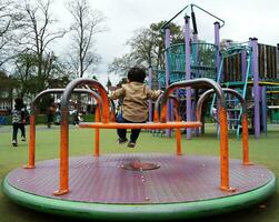 linda asiático pakistaní bebé es disfrutando el hermosa soleado día a Wardown niños y público parque de lutón pueblo de Inglaterra Reino Unido. bajo ángulo imagen estaba capturado en abril 03, 2023 foto