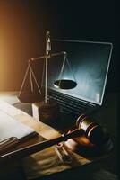 law legal technology concept. judge gavel on computer with scales of justice on desk of lawyer. photo