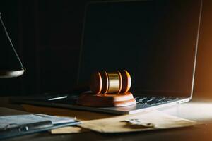 law legal technology concept. judge gavel on computer with scales of justice on desk of lawyer. photo
