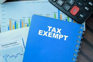 Concept of Tax Exempt write on book isolated on Wooden Table. photo