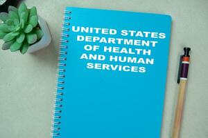 Concept of United States Department Of Health And Human Services write on book isolated on Wooden Table. photo