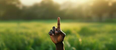 Biracial man s hand showing peace sign on grass background emphasizing peace and anti war movement photo