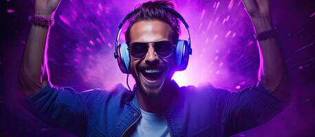 Man dancing happily and wearing headphones DJ smiling hipster displaying the world sign with fingers portrait on purple background with neon light photo