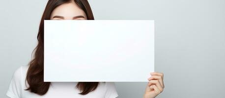 asiático mujer posando con blanco cartelera para texto y Copiar foto