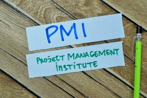 Concept of PMI - Project Management Institute write on sticky notes isolated on Wooden Table. photo