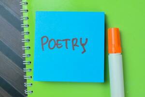 Concept of Poetry write on sticky notes isolated on Wooden Table. photo