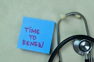 Concept of Time To Renew write on sticky notes with stethoscope isolated on Wooden Table. photo
